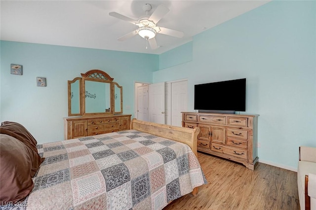 bedroom featuring ceiling fan, lofted ceiling, light wood-type flooring, and a closet