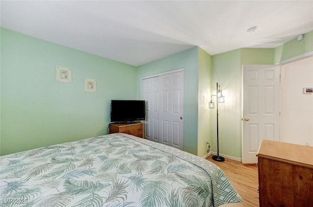 bedroom with light hardwood / wood-style floors and a closet