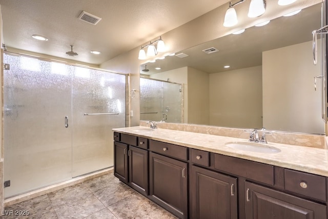 bathroom with vanity and a shower with door