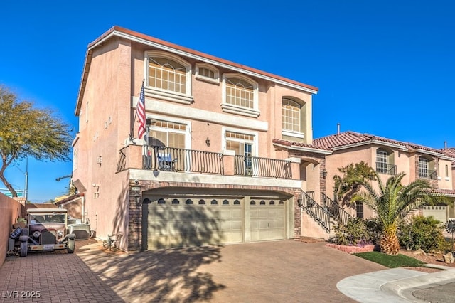 view of front of home featuring a balcony, a garage, and central AC unit