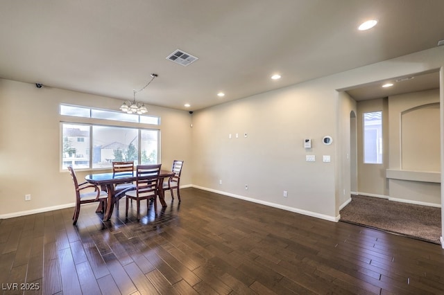 dining area featuring dark wood-type flooring and a notable chandelier