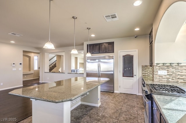 kitchen with stainless steel appliances, light stone countertops, a center island, and a breakfast bar area