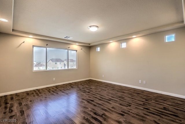 unfurnished room featuring dark hardwood / wood-style floors and a textured ceiling