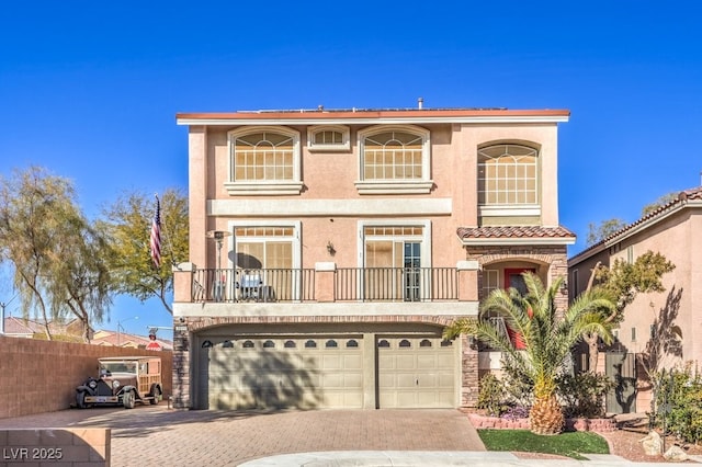 5490 Tulip Hill Ave, Las Vegas, NV 89141 - view of front of house featuring a balcony, decorative driveway, a garage, stucco siding, and stone siding