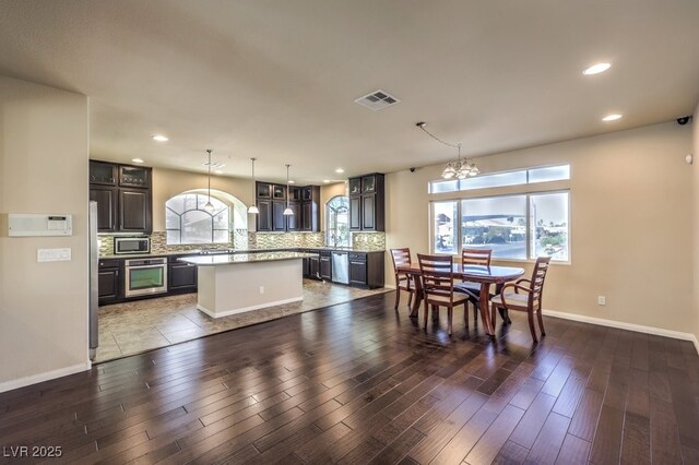 5490 Tulip Hill Ave, Las Vegas, NV 89141 - kitchen with appliances with stainless steel finishes, a center island, backsplash, a chandelier, and light countertops