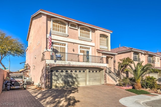 5490 Tulip Hill Ave, Las Vegas, NV 89141 - mediterranean / spanish home with concrete driveway, stucco siding, an attached garage, and a balcony