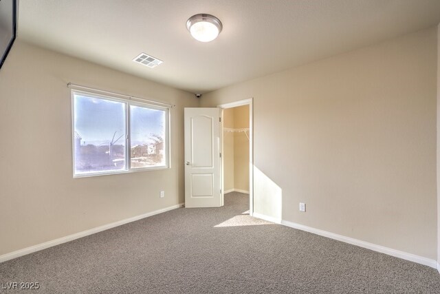5490 Tulip Hill Ave, Las Vegas, NV 89141 - unfurnished bedroom featuring carpet floors, a walk in closet, and baseboards