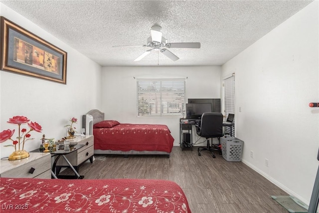 bedroom with ceiling fan, dark hardwood / wood-style floors, and a textured ceiling