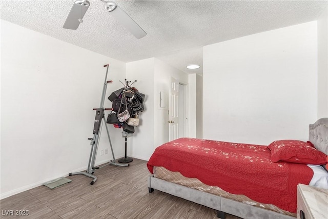 bedroom featuring hardwood / wood-style flooring, a textured ceiling, and ceiling fan