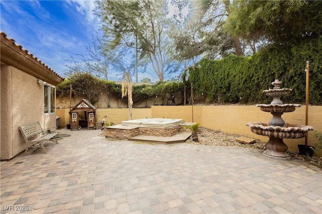 view of patio / terrace with a fenced backyard and an outdoor hot tub