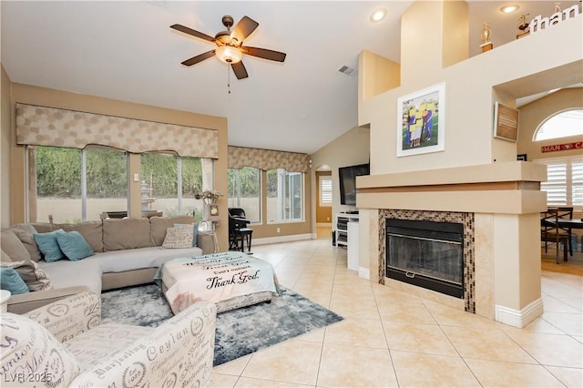 living room with light tile patterned floors, ceiling fan, visible vents, and a tiled fireplace