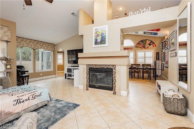 living room featuring a fireplace, visible vents, a ceiling fan, and light tile patterned flooring