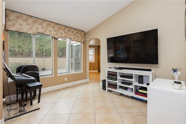 living area with lofted ceiling, light tile patterned flooring, arched walkways, and baseboards