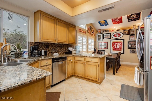 kitchen with light tile patterned floors, stainless steel appliances, visible vents, a sink, and a peninsula