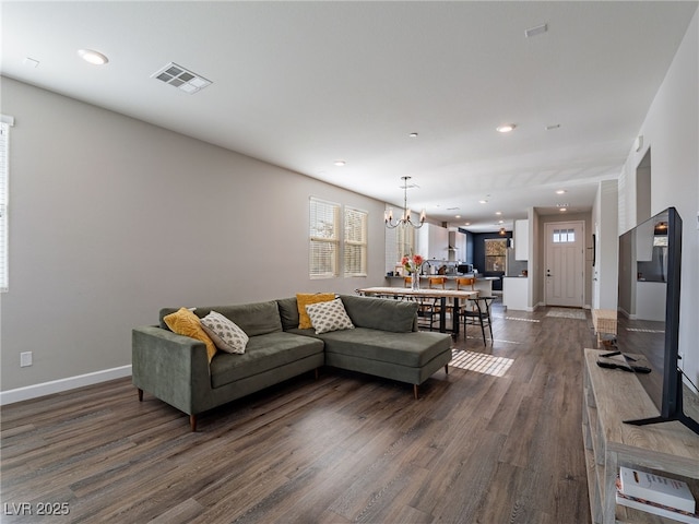 living room with an inviting chandelier and dark hardwood / wood-style floors