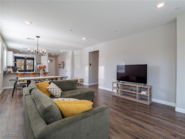 living room with a notable chandelier and hardwood / wood-style flooring