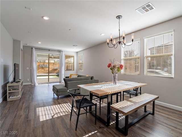 dining area featuring a notable chandelier and dark wood-type flooring