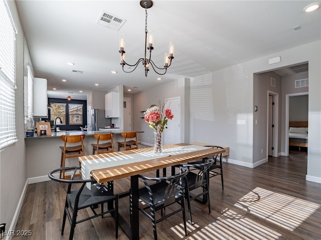 dining room with dark hardwood / wood-style flooring and a chandelier