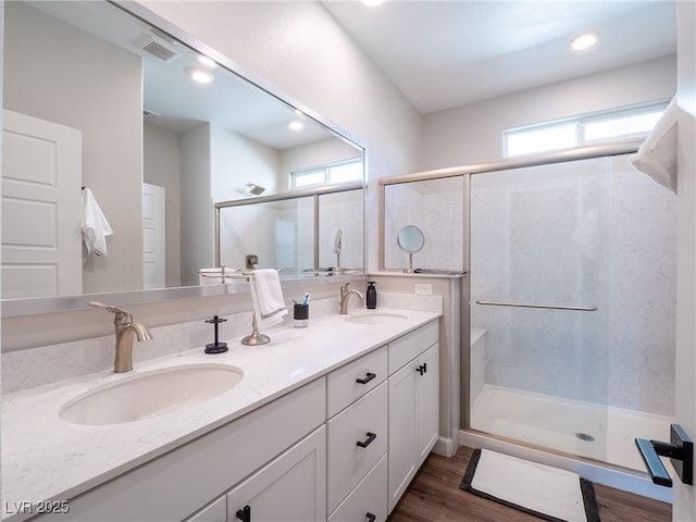 bathroom featuring walk in shower, vanity, and hardwood / wood-style floors