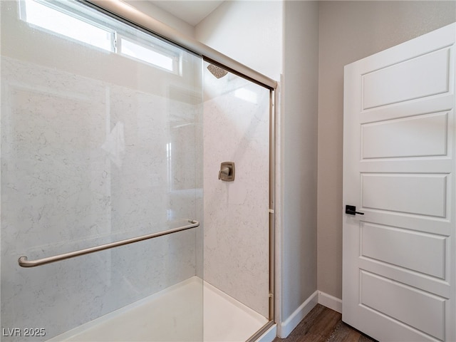 bathroom with hardwood / wood-style flooring and walk in shower