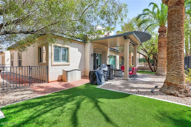 exterior space with a yard, a patio area, fence, and stucco siding