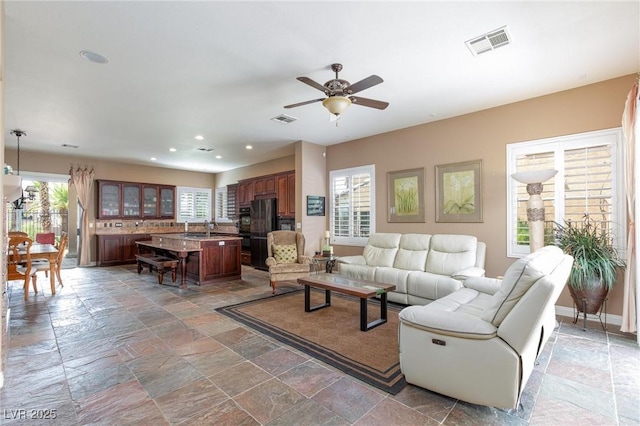 living room featuring sink and ceiling fan