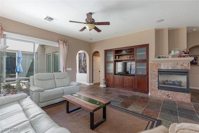 living room featuring a fireplace and ceiling fan