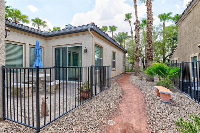 view of home's exterior with stucco siding and fence