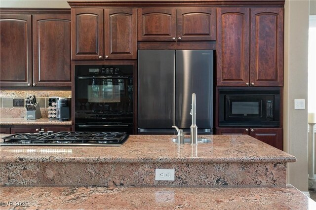 kitchen with light stone counters, black appliances, and dark brown cabinetry