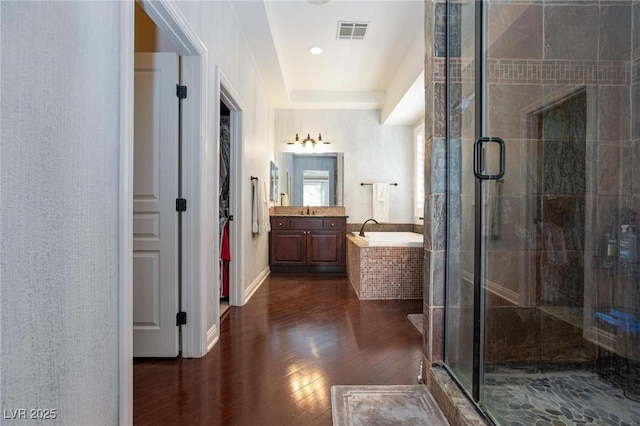 bathroom featuring independent shower and bath, wood-type flooring, and vanity