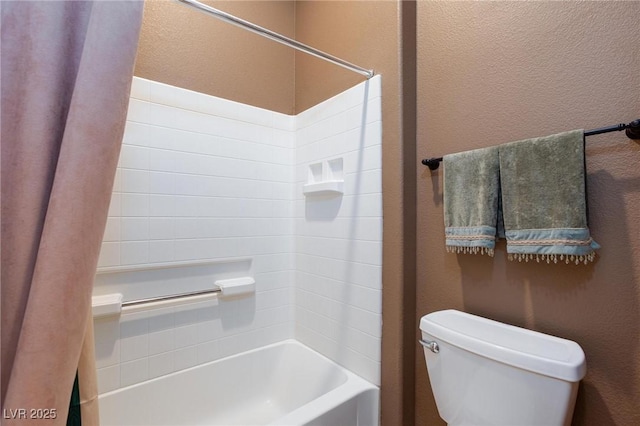 full bath with toilet, shower / bathtub combination, and a textured wall