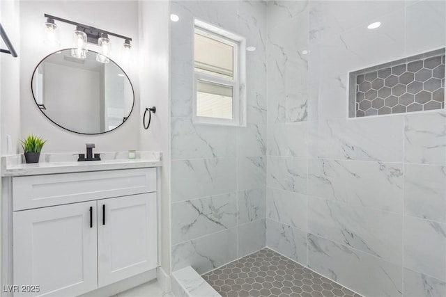 bathroom featuring tiled shower and vanity