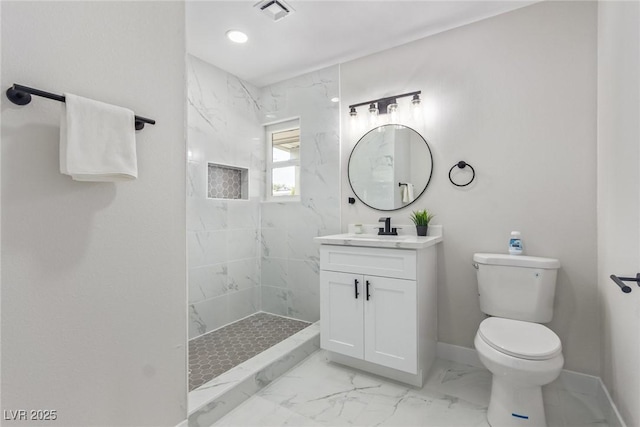 bathroom with tiled shower, vanity, and toilet