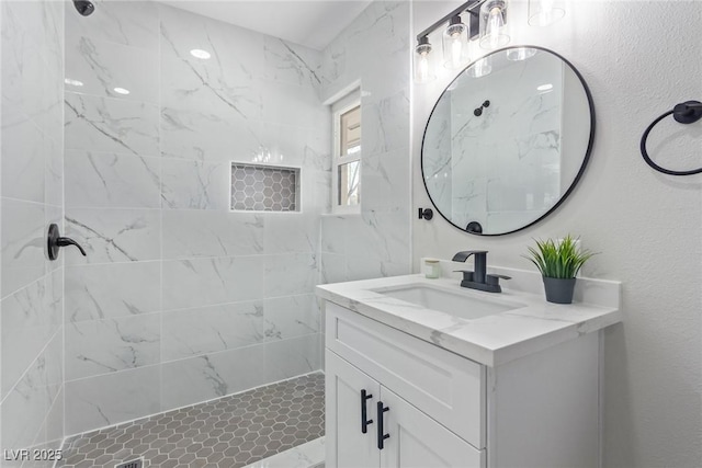 bathroom with vanity and tiled shower