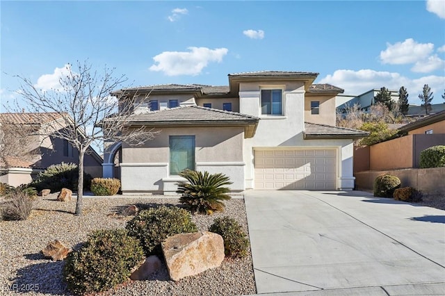 view of front facade featuring fence, an attached garage, stucco siding, concrete driveway, and a tiled roof