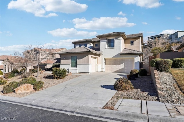 view of front of property featuring a tiled roof, a garage, driveway, and stucco siding