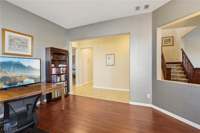 office area featuring wood finished floors, visible vents, and baseboards