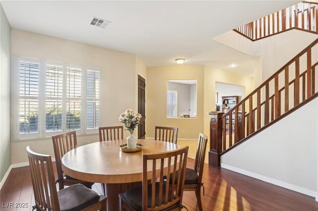 dining area featuring visible vents, stairs, baseboards, and wood-type flooring