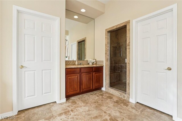 bathroom with recessed lighting, vanity, and a shower stall