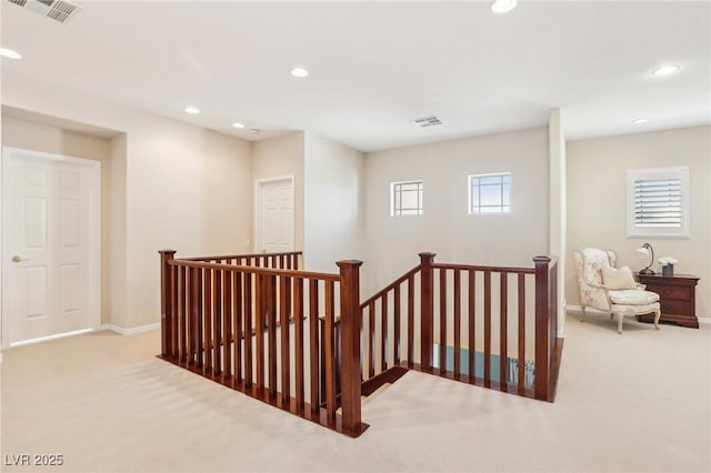 hall with an upstairs landing, visible vents, recessed lighting, and carpet floors