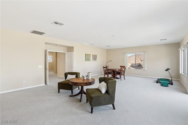 sitting room with light colored carpet, visible vents, and baseboards