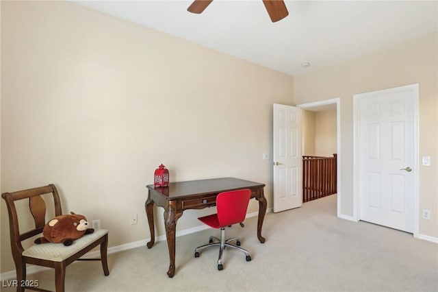 office area with baseboards, light carpet, and a ceiling fan