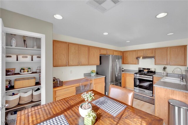 kitchen featuring stainless steel appliances, sink, and light wood-type flooring