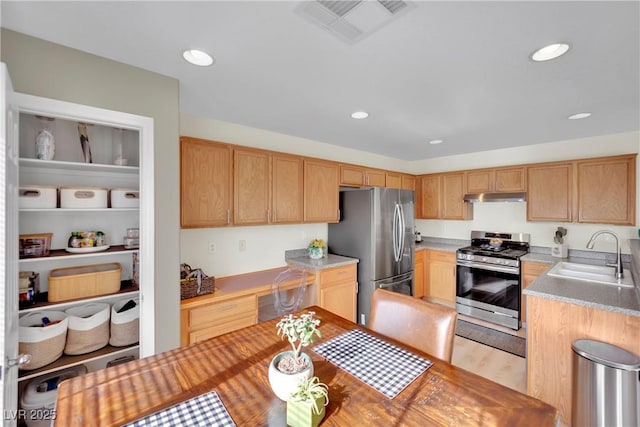 kitchen featuring visible vents, stainless steel appliances, light countertops, under cabinet range hood, and a sink