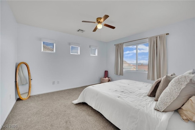 carpeted bedroom featuring visible vents, ceiling fan, and baseboards