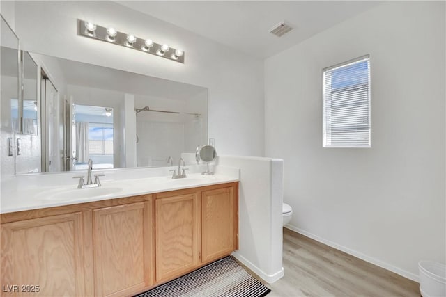 full bath with double vanity, visible vents, a shower, toilet, and a sink