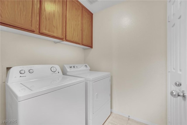 clothes washing area featuring cabinet space, light tile patterned floors, baseboards, and washing machine and clothes dryer