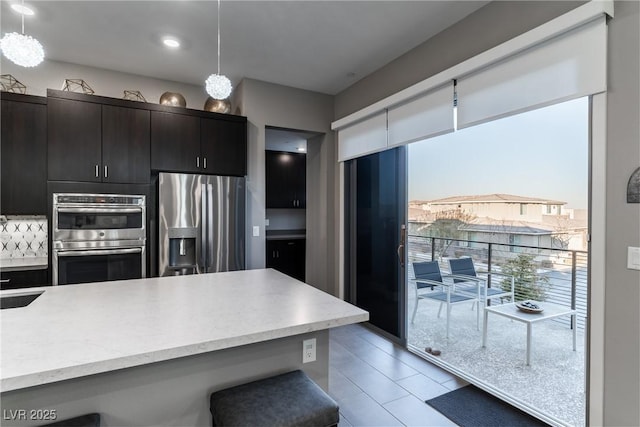 kitchen with pendant lighting, sink, a breakfast bar area, and stainless steel appliances