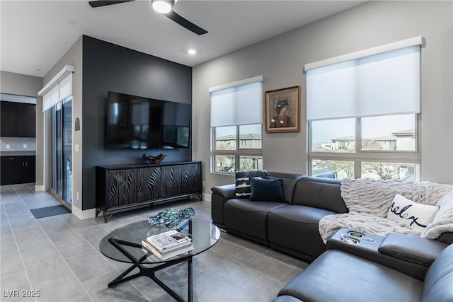 living area with a ceiling fan, recessed lighting, baseboards, and light tile patterned floors