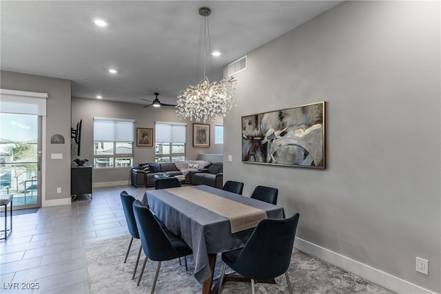 dining space featuring tile patterned floors and ceiling fan with notable chandelier